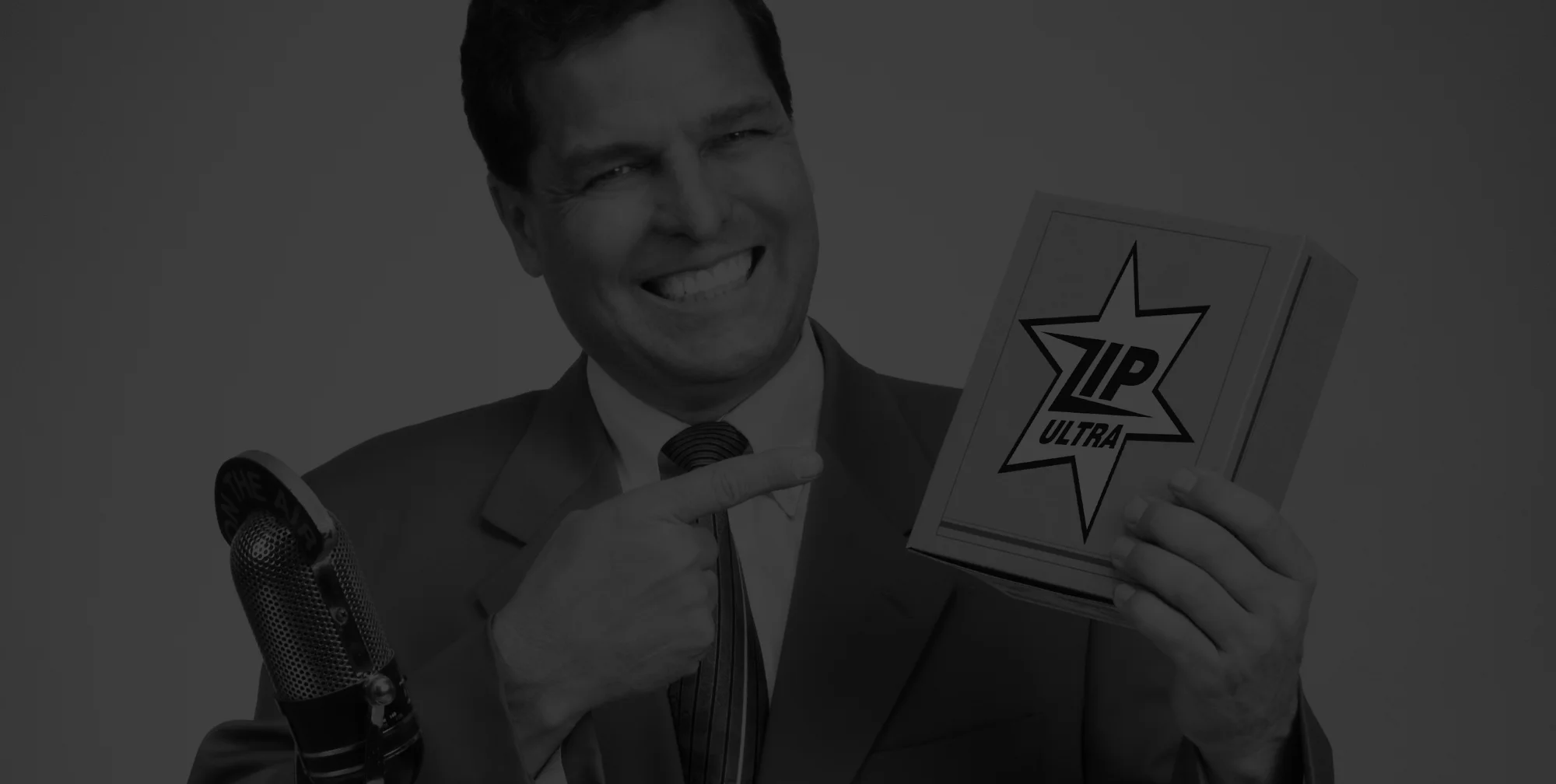 Man smiling while holding up a box with branding
